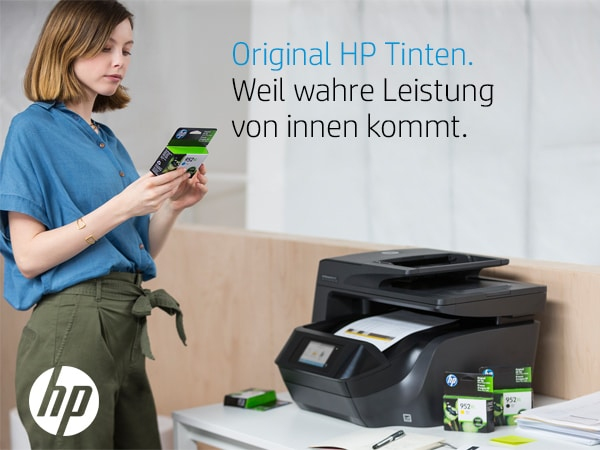 Eine Frau hält eine Tintenpatrone in der Nähe eines Druckers und Tintenpatronen.