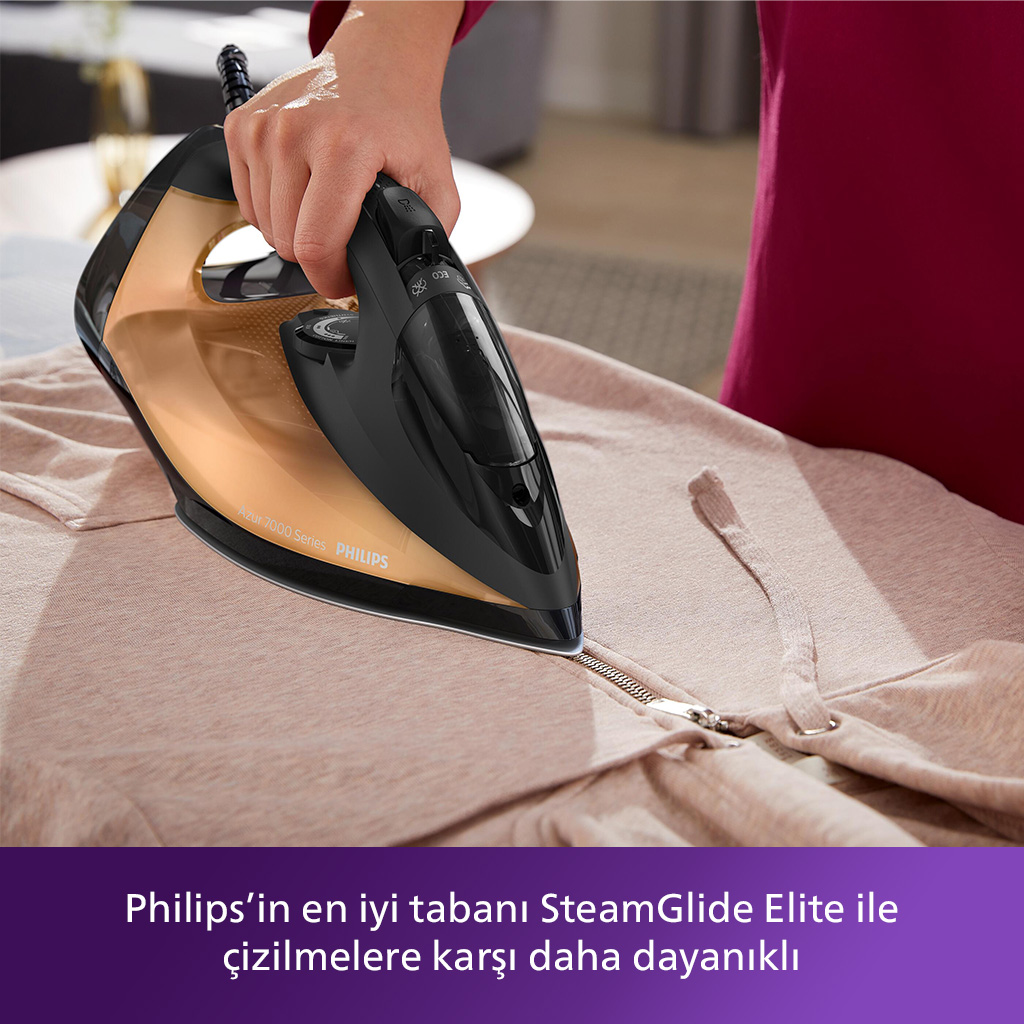 Siyah ve altın ütüyle açık renkli bir ceketi ütüleyen bir kişi. Metin şöyle der: Philips'in en iyi tabanı...