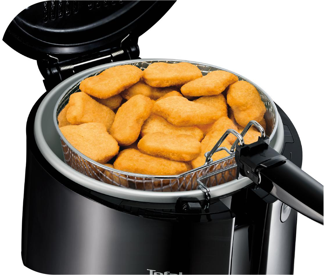 Frittierte Chicken Nuggets in einem silbernen Korb in einer schwarzen Fritteuse.