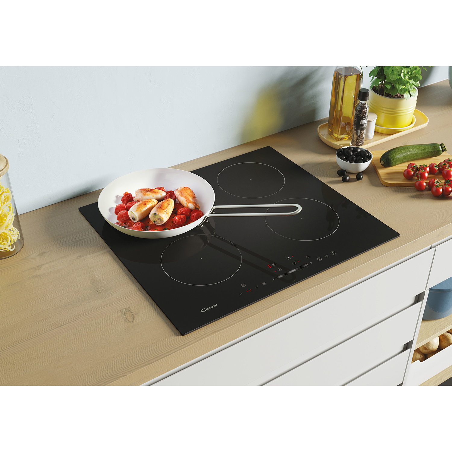 Piano cottura nero con quattro zone cottura, con una padella con cibo e altri ingredienti.