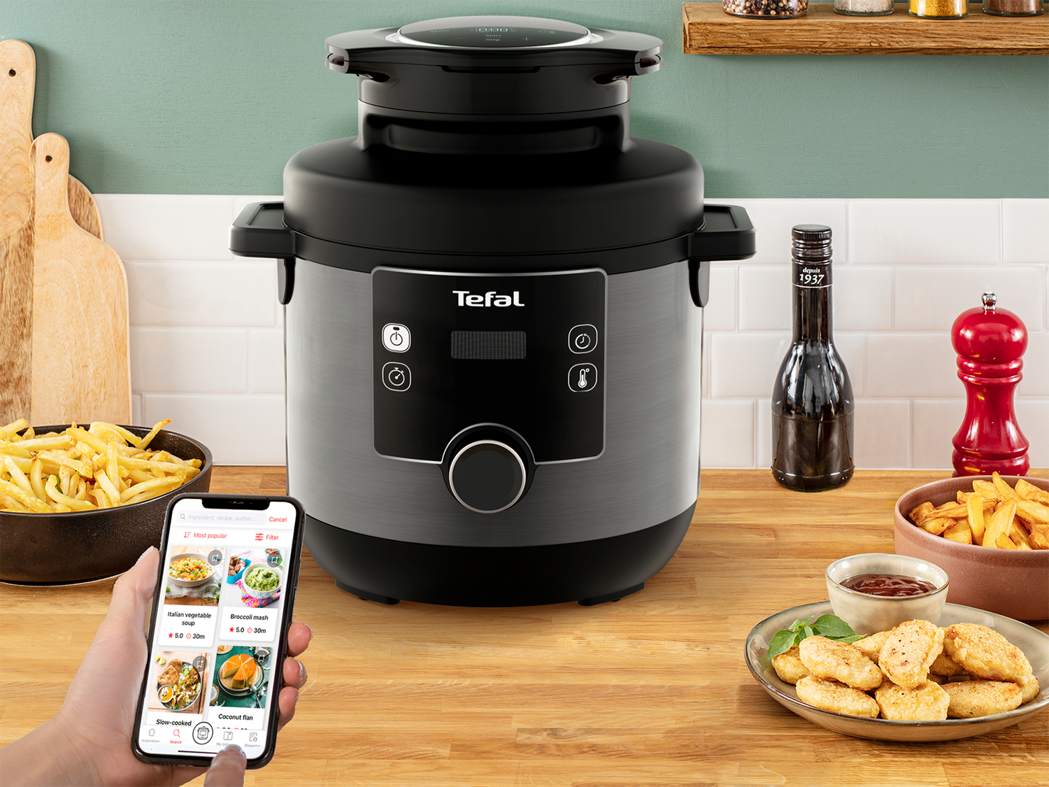 Een snelkookpan met een telefoon met recepten en bijgerechten: friet, nuggets, saus.