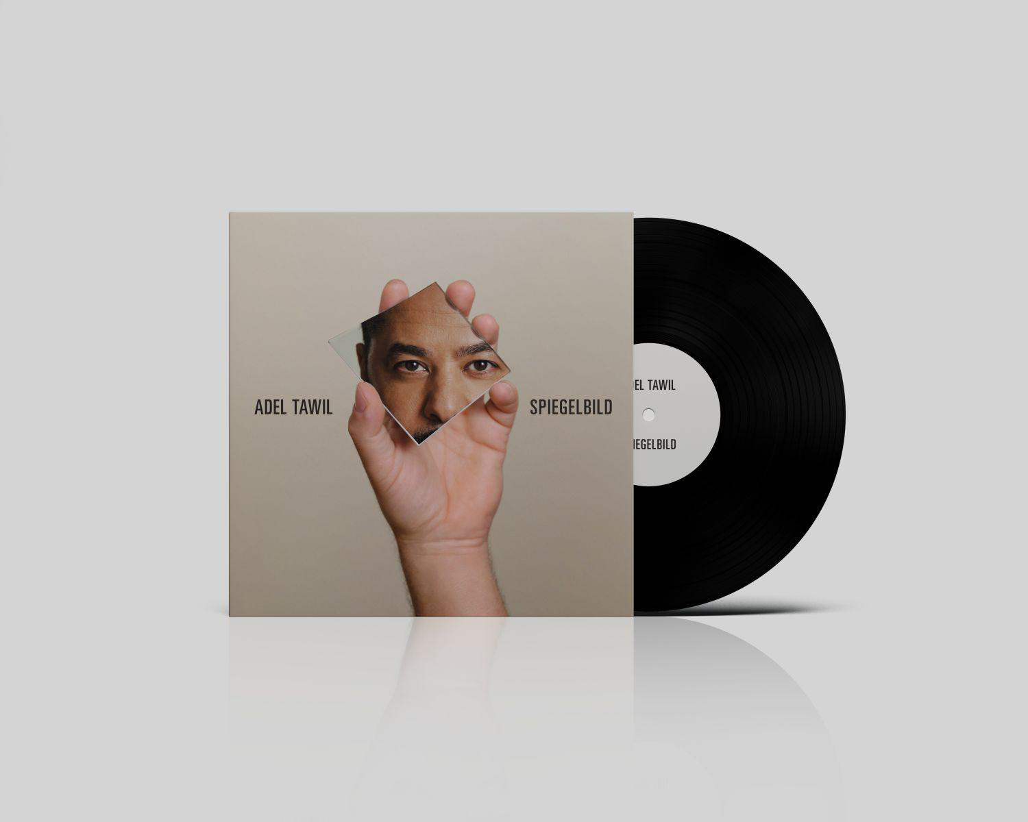 Albumcover mit dem Gesicht eines Mannes in einem Spiegel, neben einer Schallplatte.