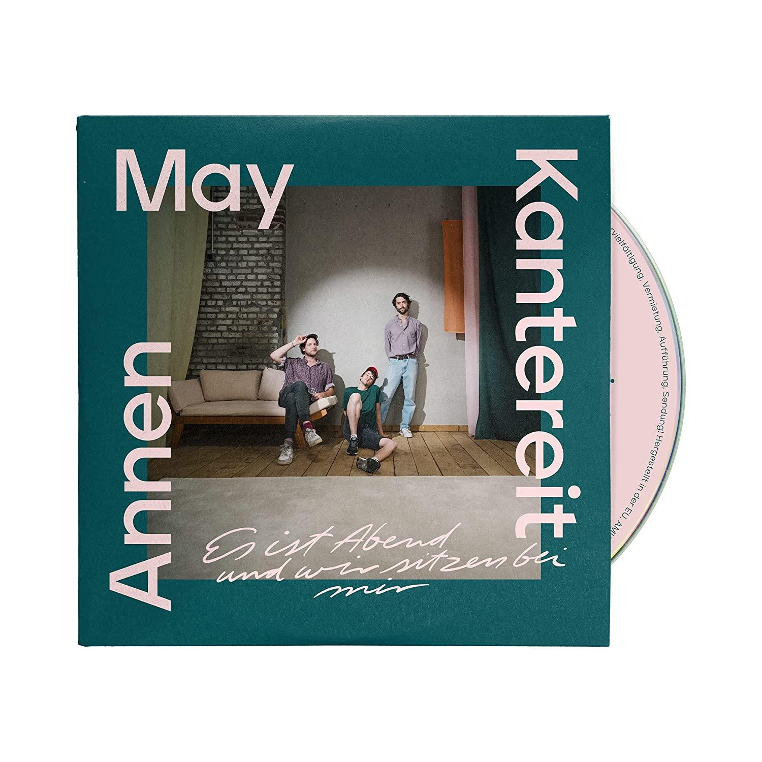 Musikalbum-Cover, drei Personen sitzen in einem Raum, Text: AnnenMayKantereit, Es ist Abend.