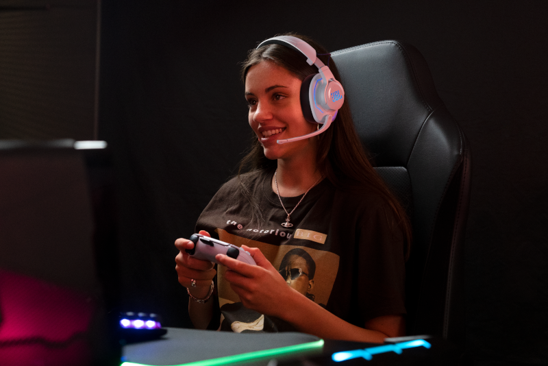 Eine Frau mit Headset spielt mit einem Controller ein Spiel.