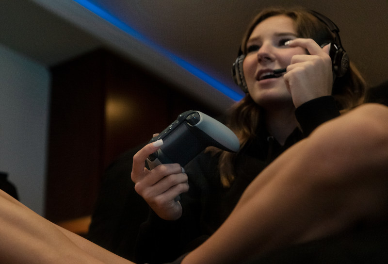 Eine Person spielt ein Videospiel mit Controller und Headset.