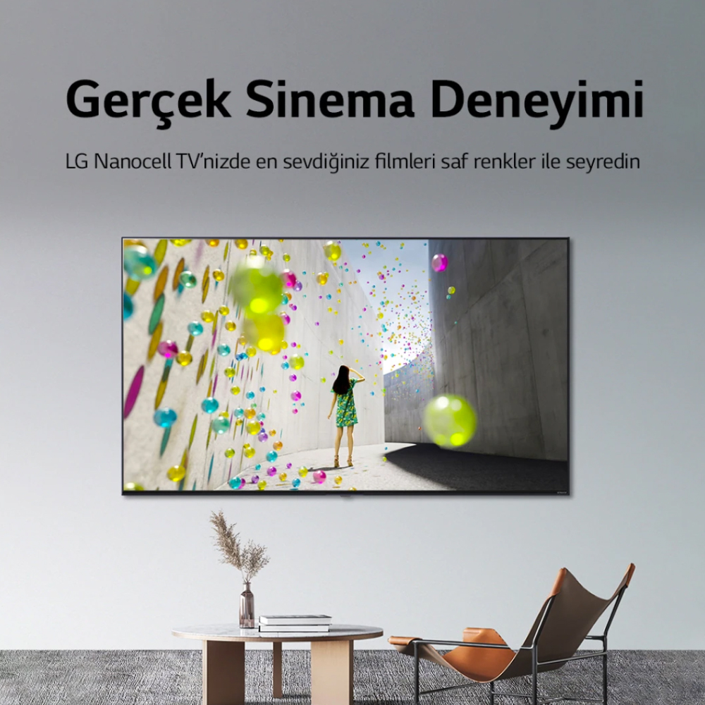 Bir TV, renkli yüzen küreler arasında yürüyen bir kişiyle bir görüntü gösteriyor.