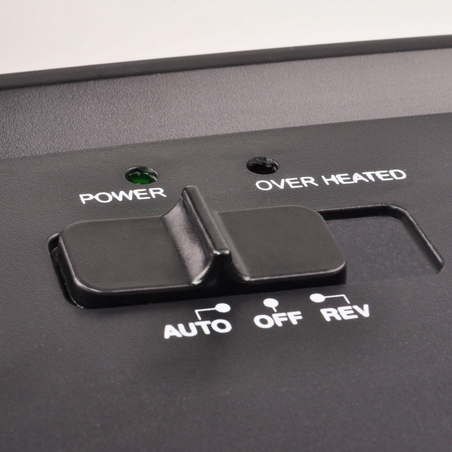Close-up of a black paper shredder control panel with power and overheat indicators.