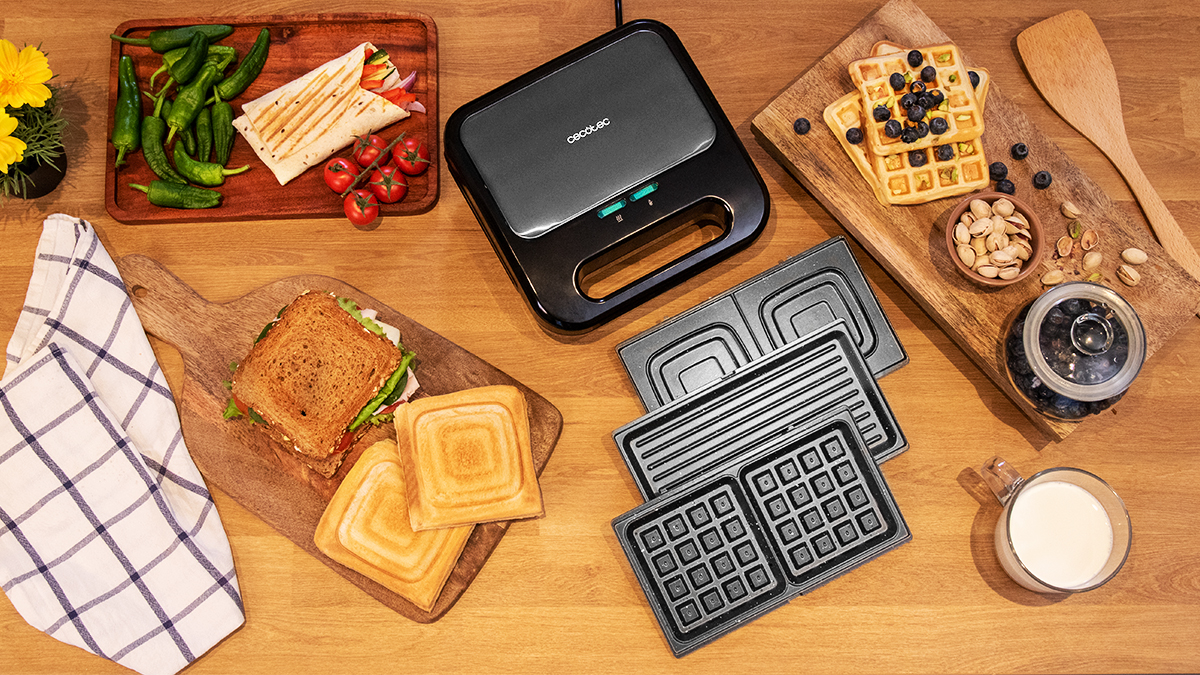 Vista cenital de una mesa con máquina de hacer gofres, insertos y comida.