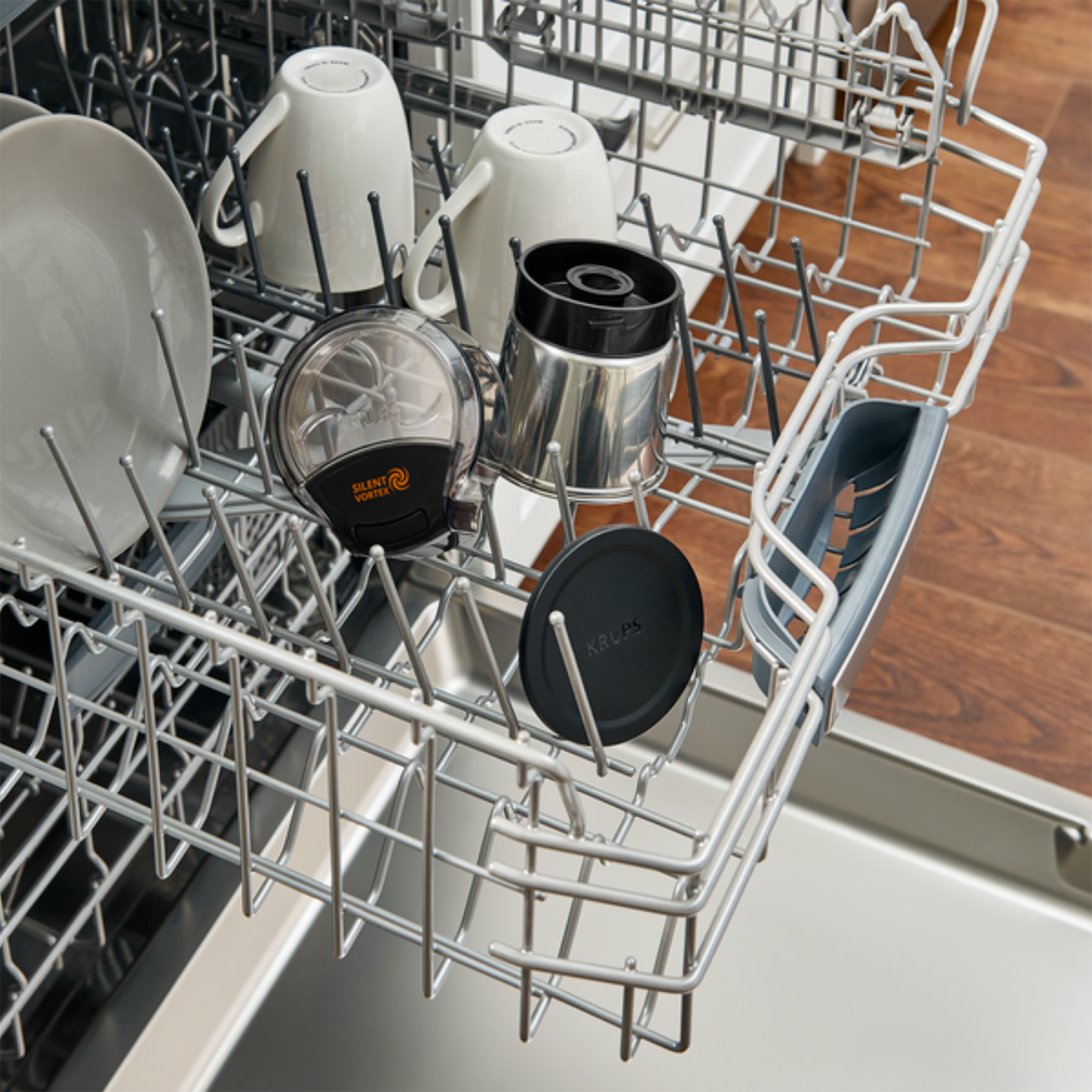 Dishwasher's interior with plates, cups, and components.