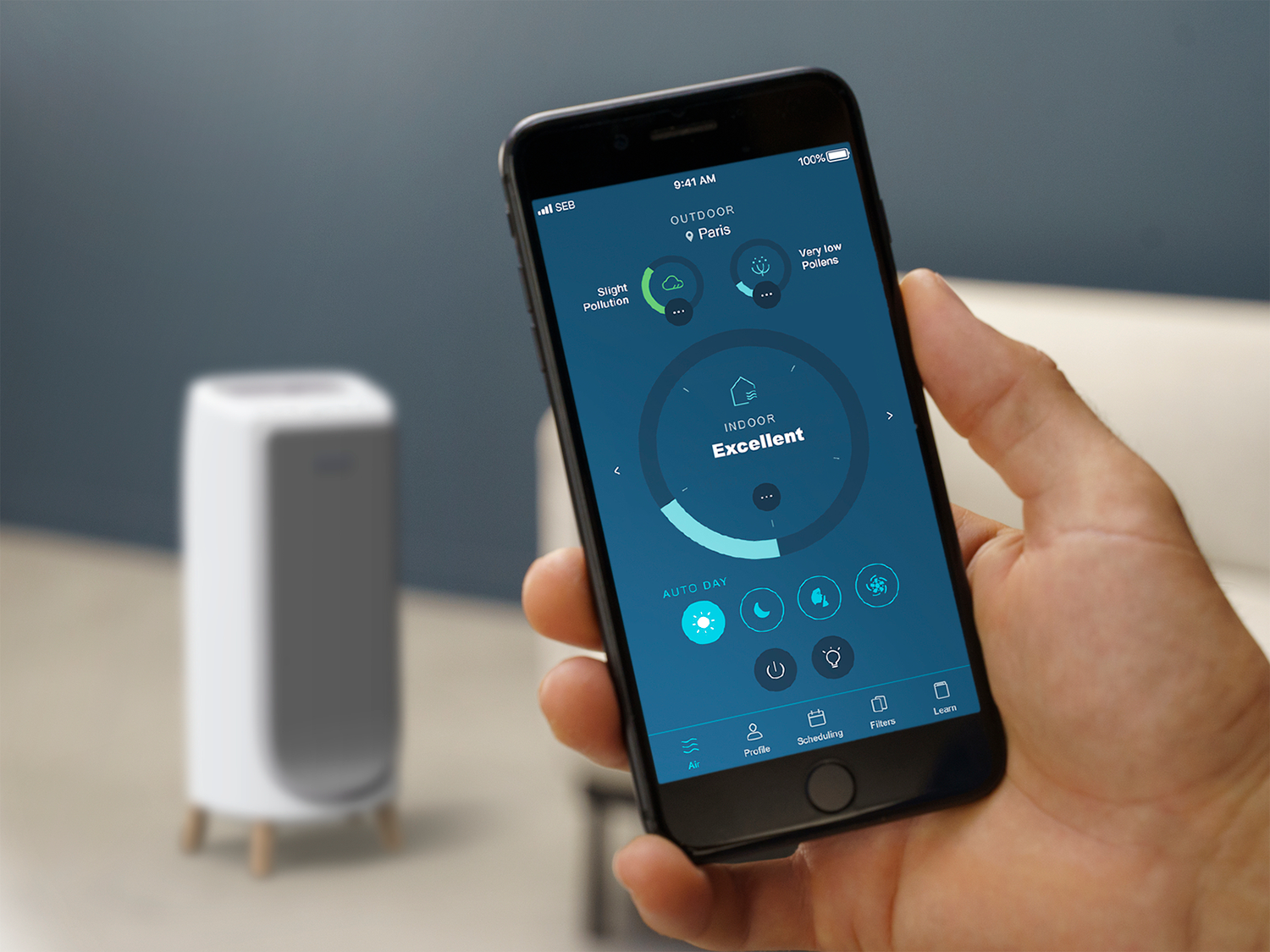 A hand holding a smartphone displaying an air purifier app.