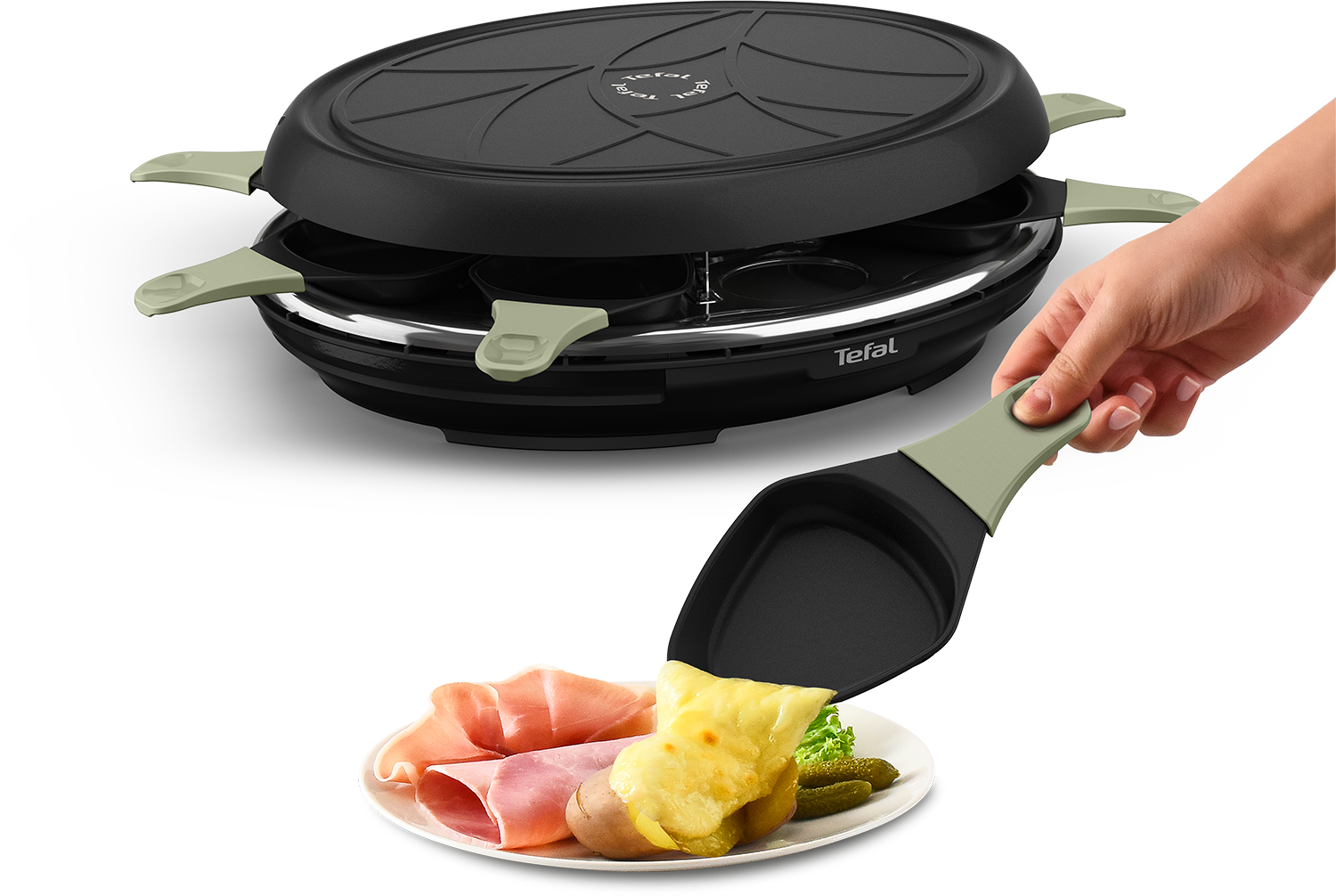Raclette set with food being served. A hand holds a spatula with cheese.