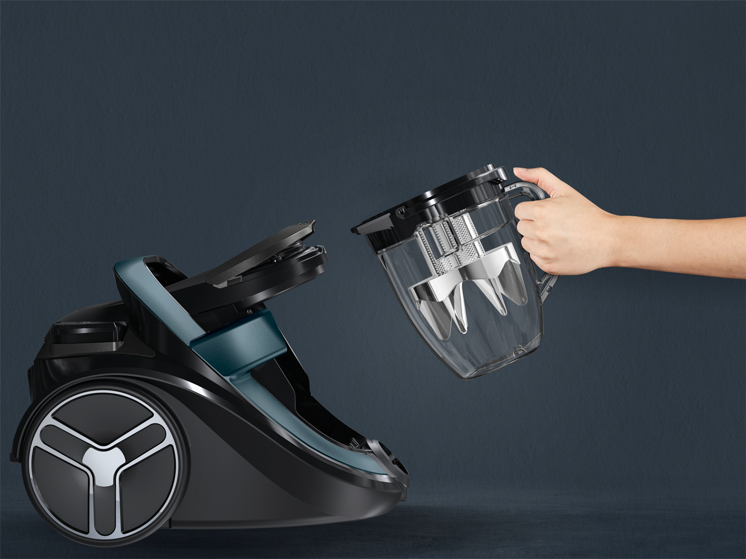 A person's hand is holding the container of vacuum.