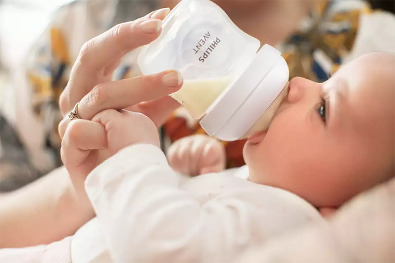 Babát Philips Avent cumisüvegből etet felnőtt.