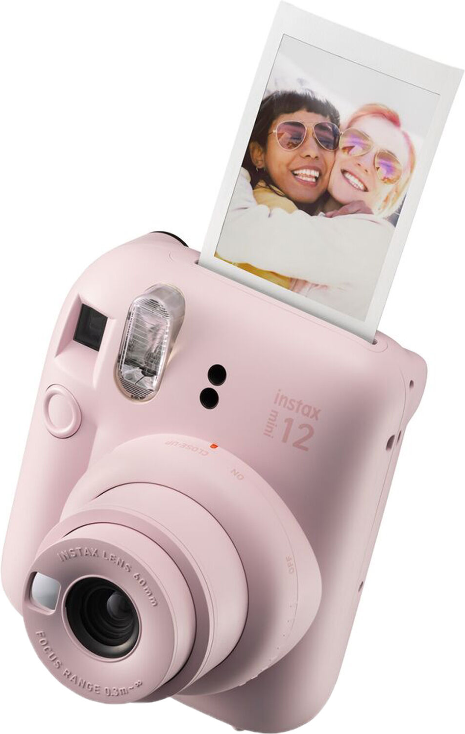 Pinke Instax Mini 12 Kamera, ein Foto wird ausgeworfen. Zwei Personen lächeln auf dem Foto.