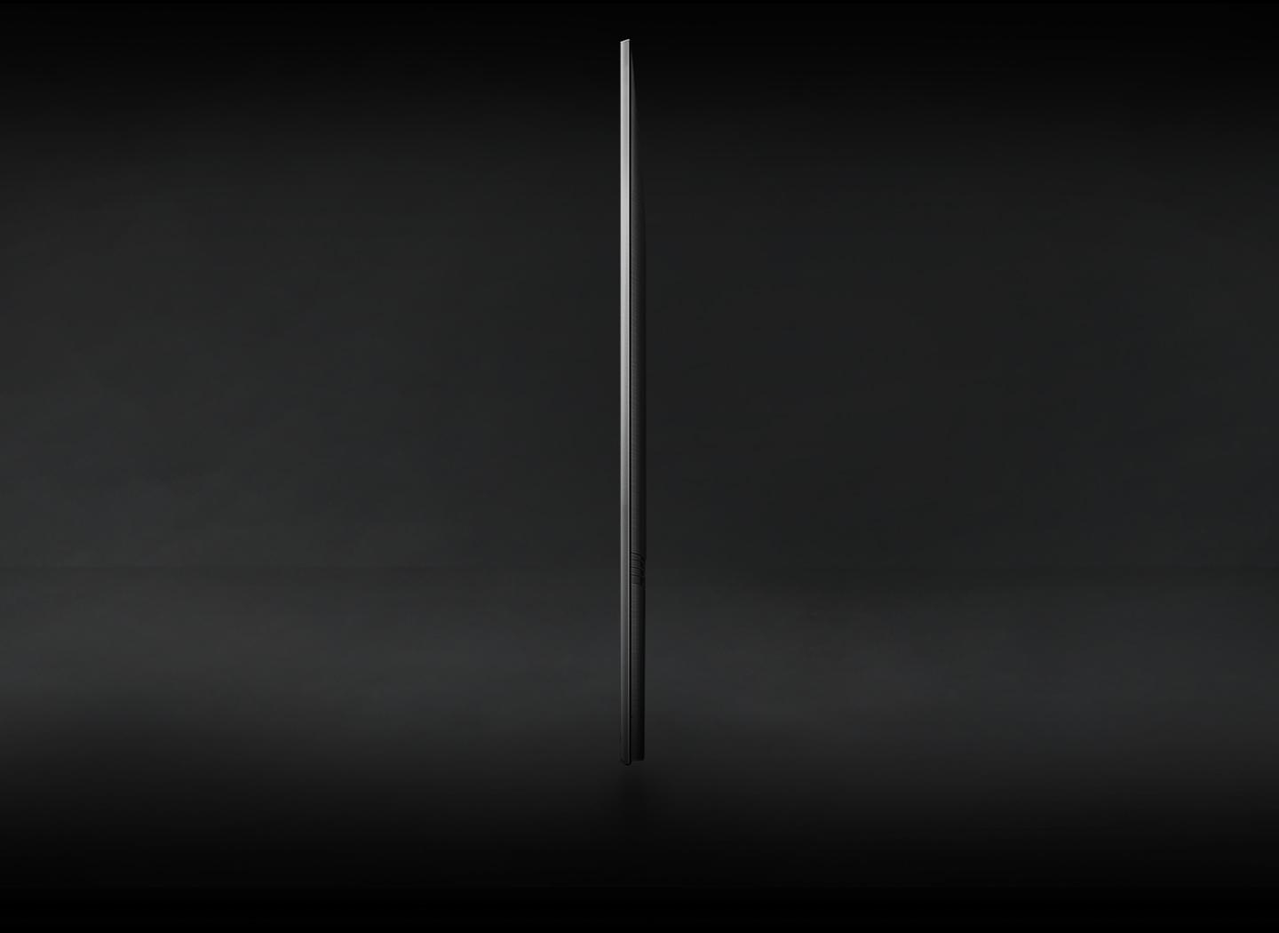 Seitenansicht eines schwarzen Fernsehers vor dunklem Hintergrund, schlankes Profil.