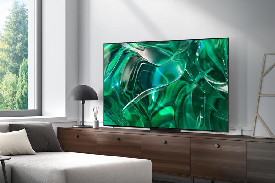 Ein modernes Wohnzimmer mit großem Fernseher auf einem Schrank, Sofa und Fenster.