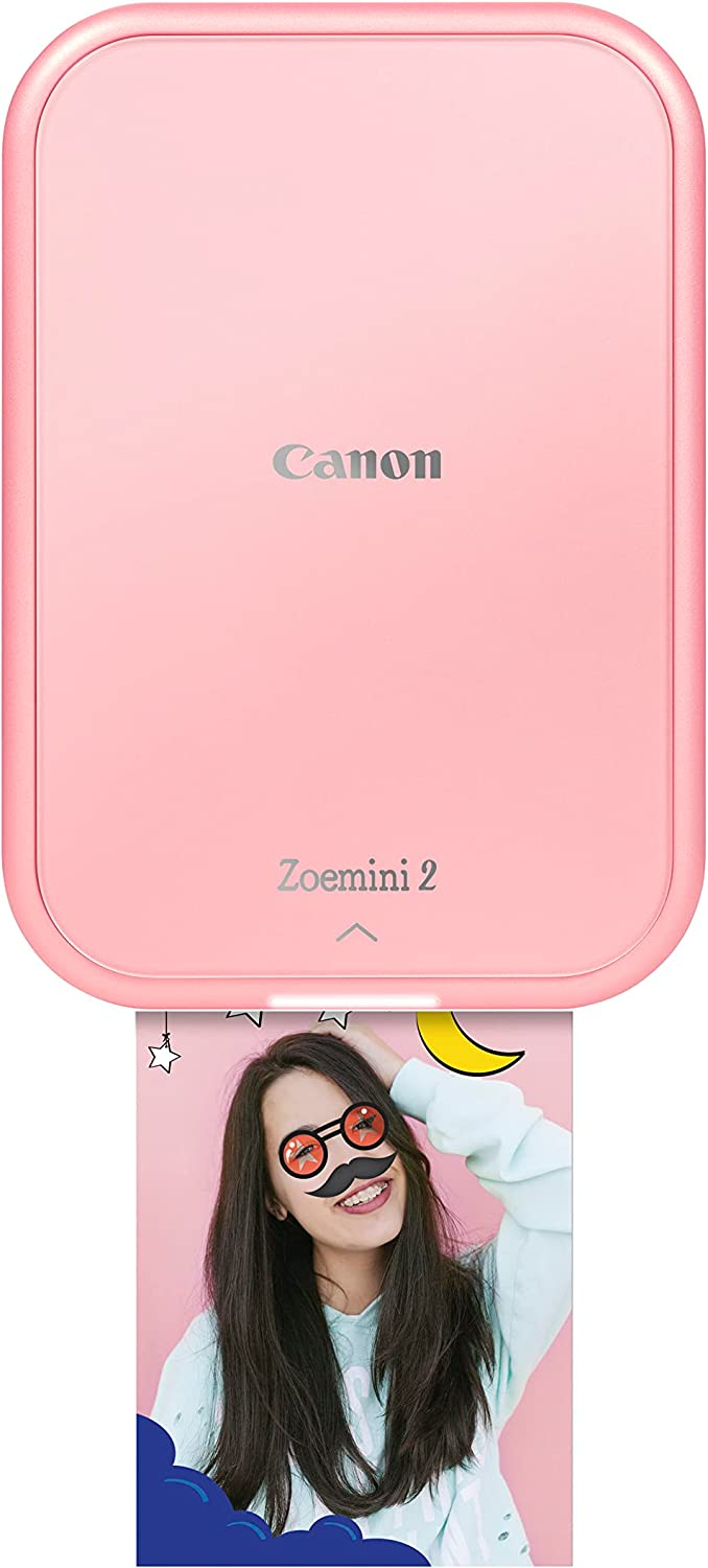 Una impresora Canon Zoemini 2 rosa imprime una foto de una mujer sonriendo.