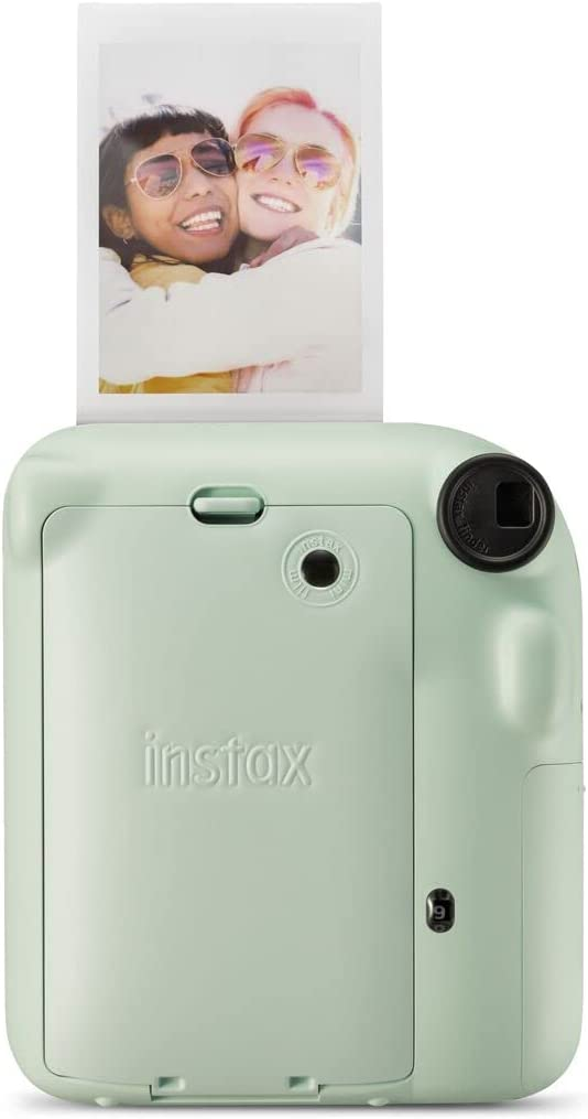 Cámara instantánea verde menta, se está expulsando una foto.
