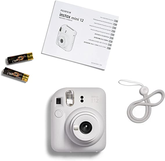Una cámara Instax Mini 12 blanca, accesorios y un manual.