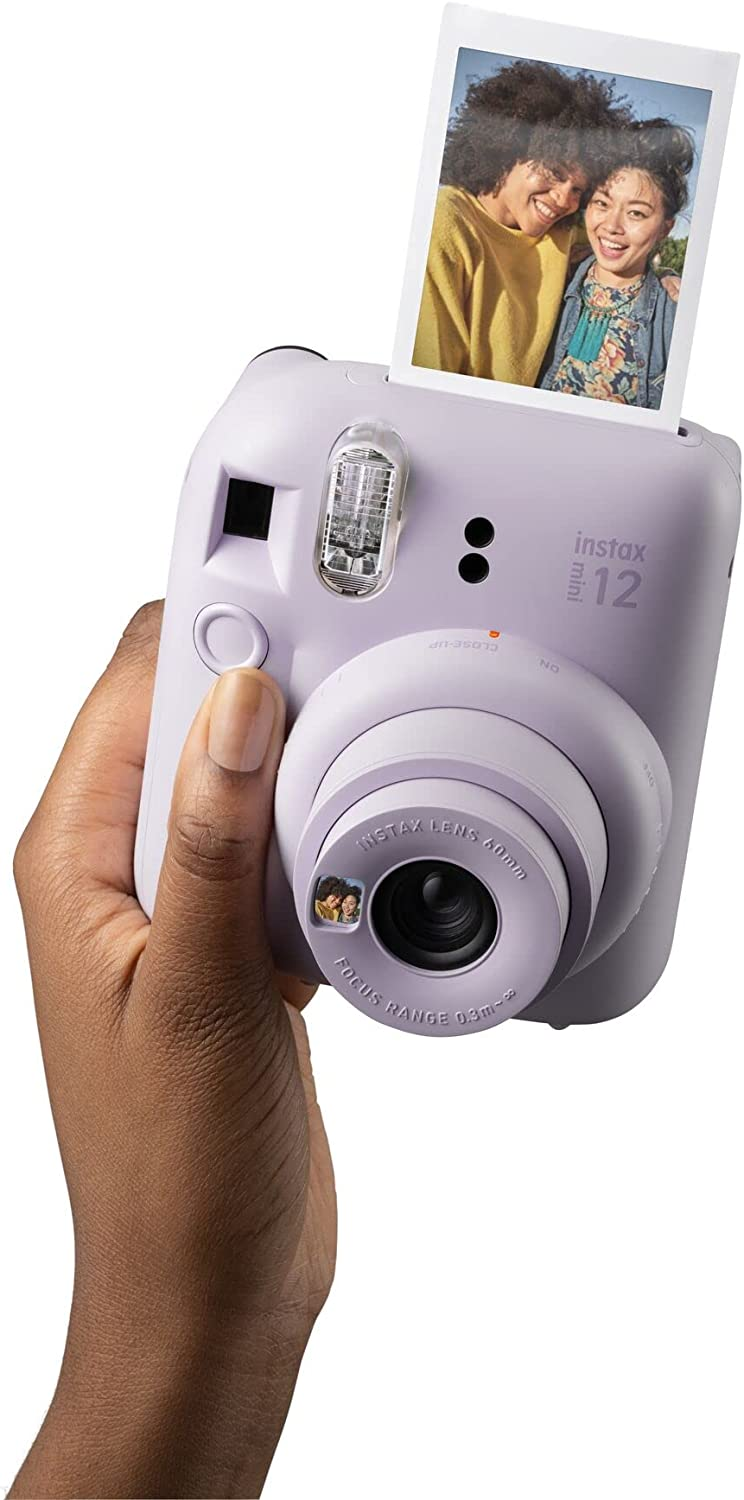 Una persona sosteniendo una cámara Instax 12 lila, tomando una foto.