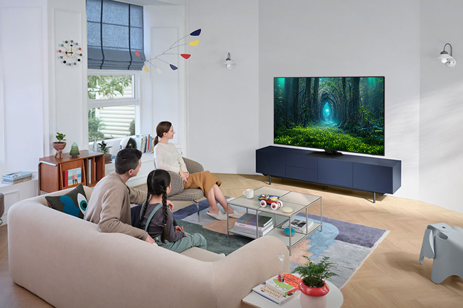 Famille regardant la TV dans le salon, TV affiche une scène de forêt.