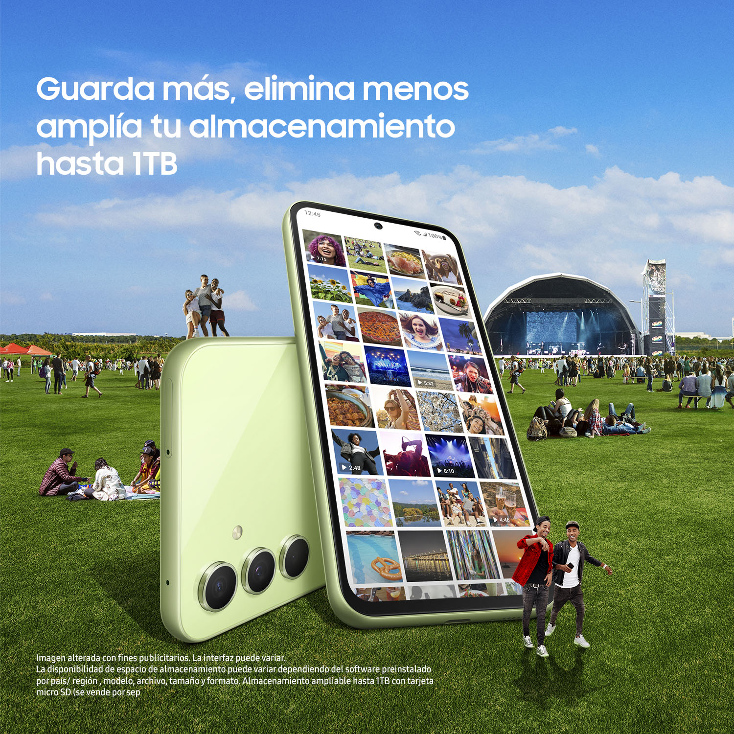 Dos teléfonos en la hierba, uno mostrando imágenes. Gente y escenario al fondo.