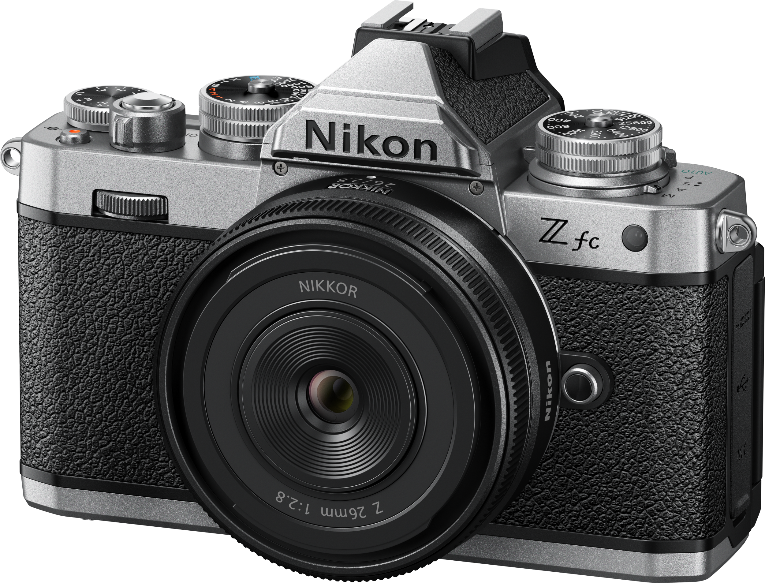 Silberne Nikon Z fc Kamera mit schwarzem Objektiv. Die Kamera steht auf weißem Untergrund.