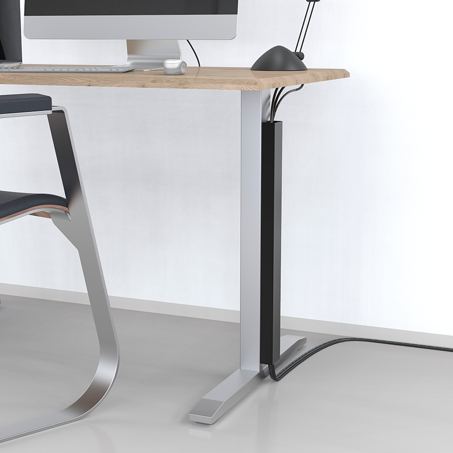 A corner of a desk with a computer, a black mouse, and a black cable management system on a white wall.