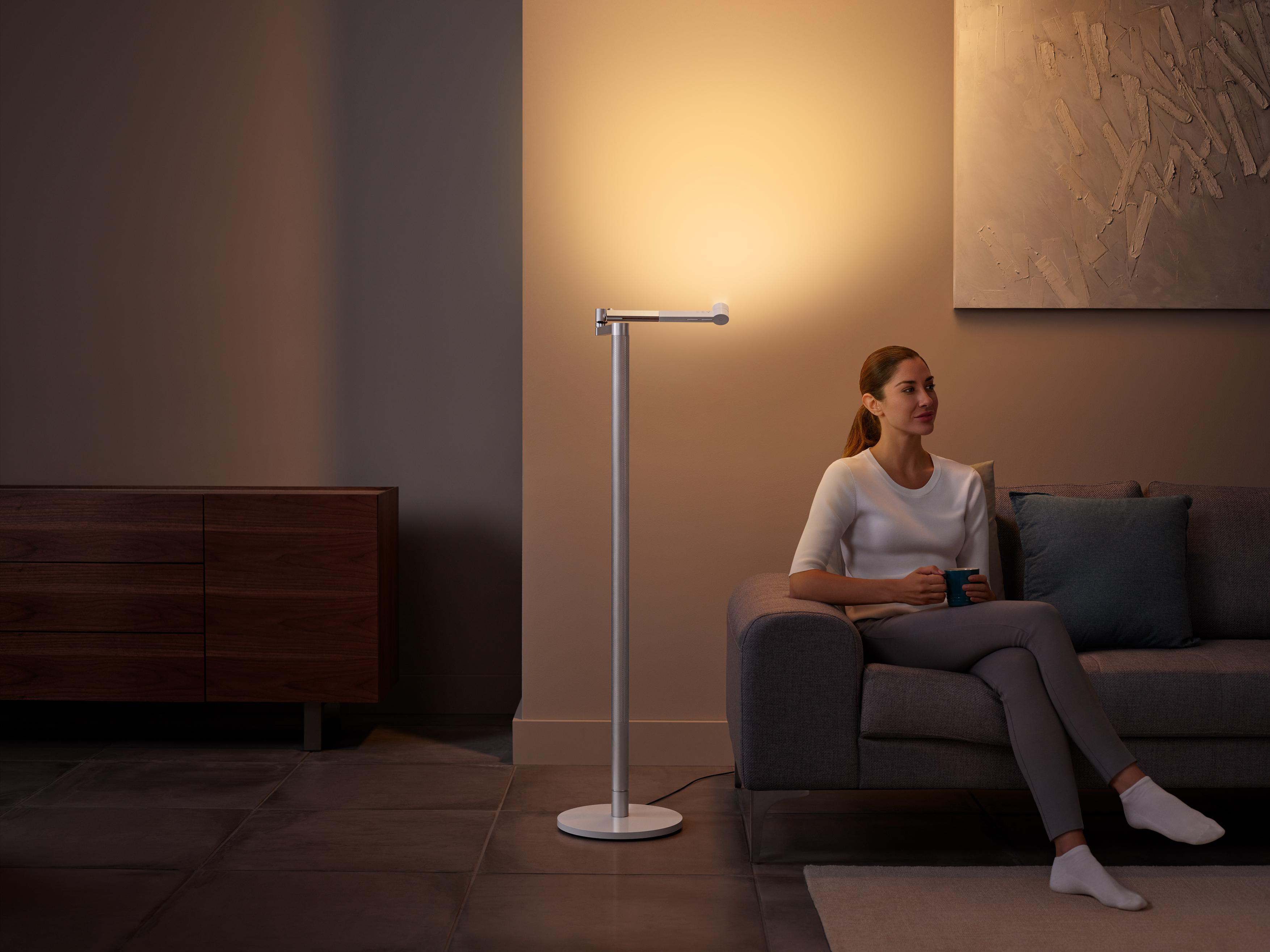 Eine Frau sitzt mit einem Licht und einem Sofa.
