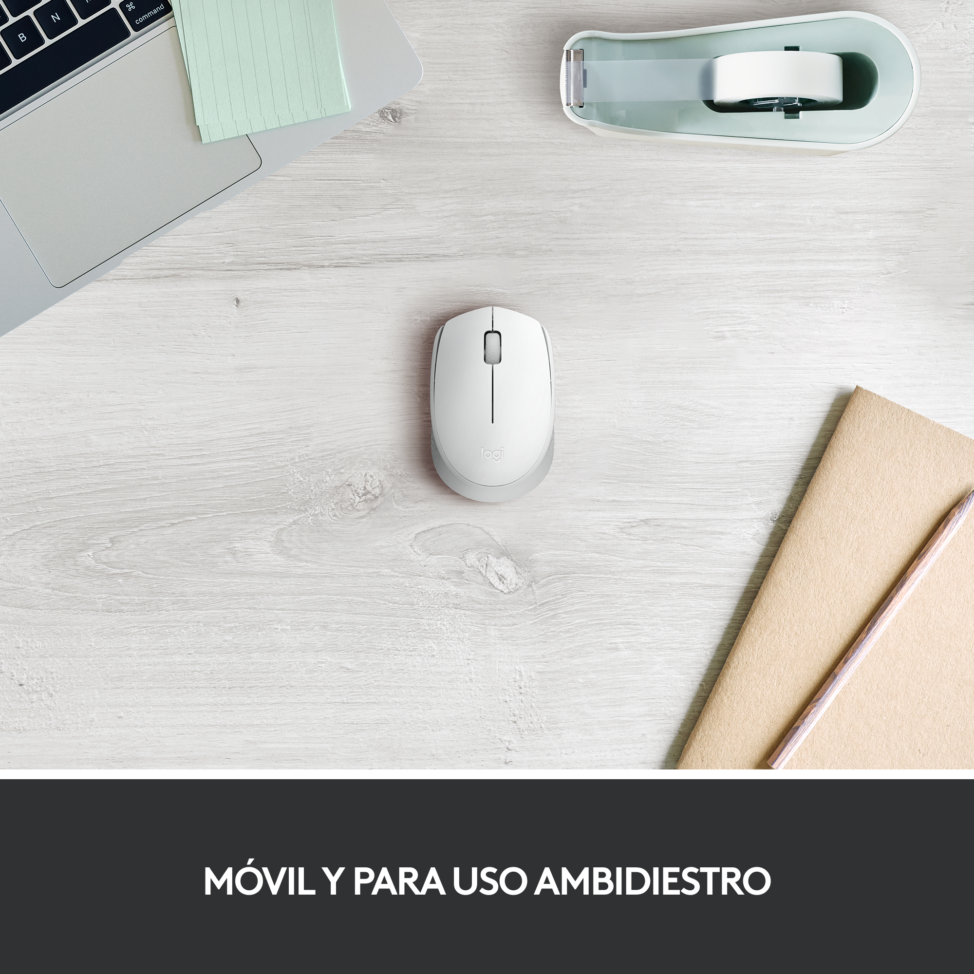 Un ratón blanco con base gris, junto a un cuaderno y un lápiz sobre un escritorio de madera.