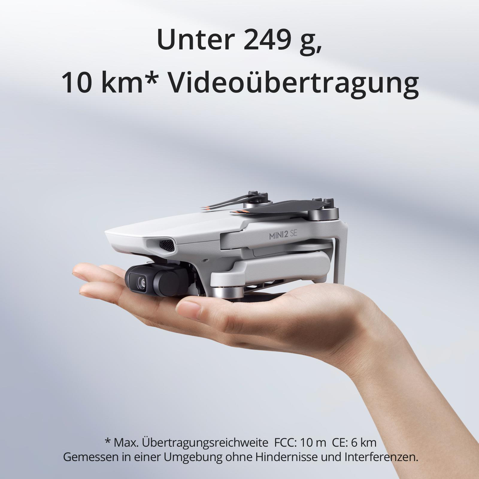 Eine weiße Drohne in der Hand, mit Text über die Videoübertragungsreichweite.
