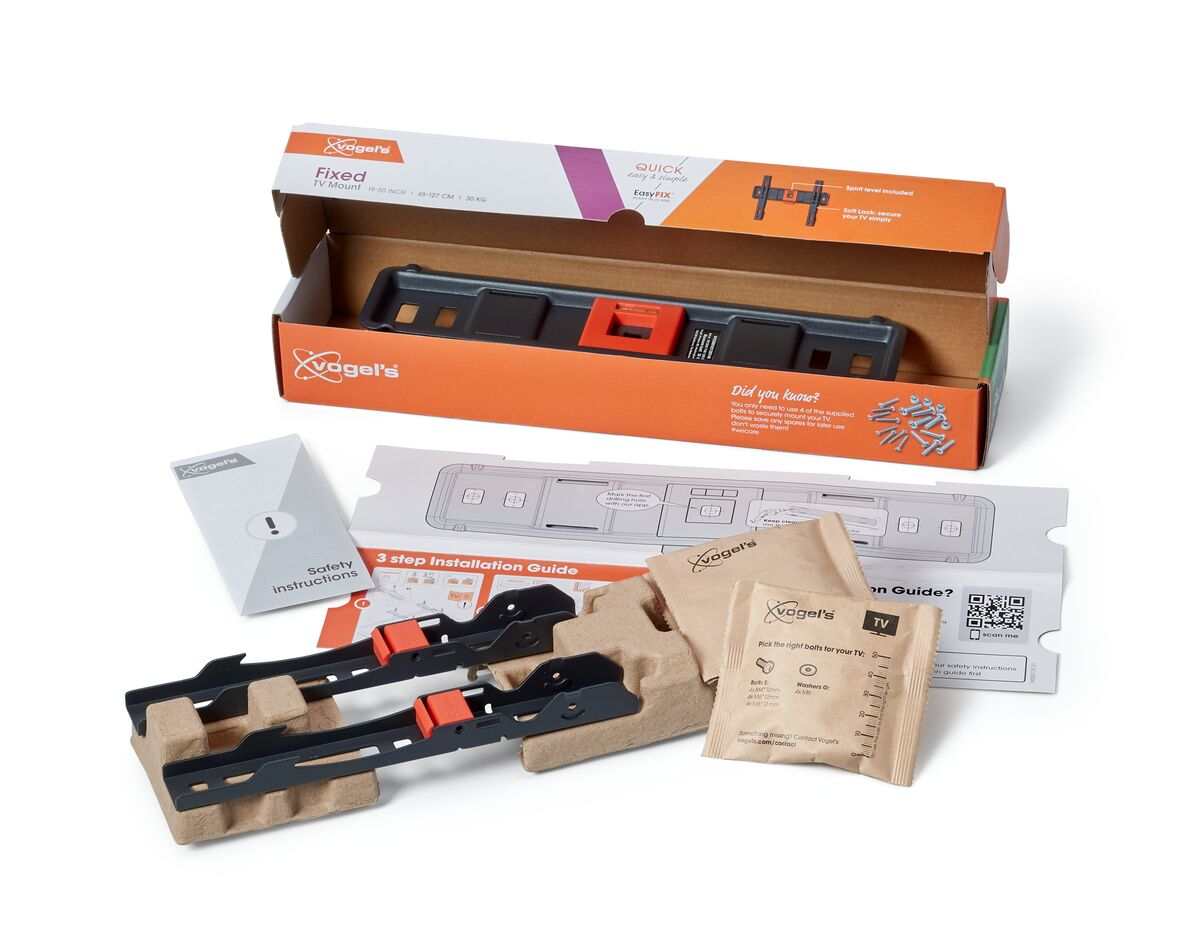 Kit de montaje de TV en caja abierta con instrucciones y accesorios. Fondo blanco.
