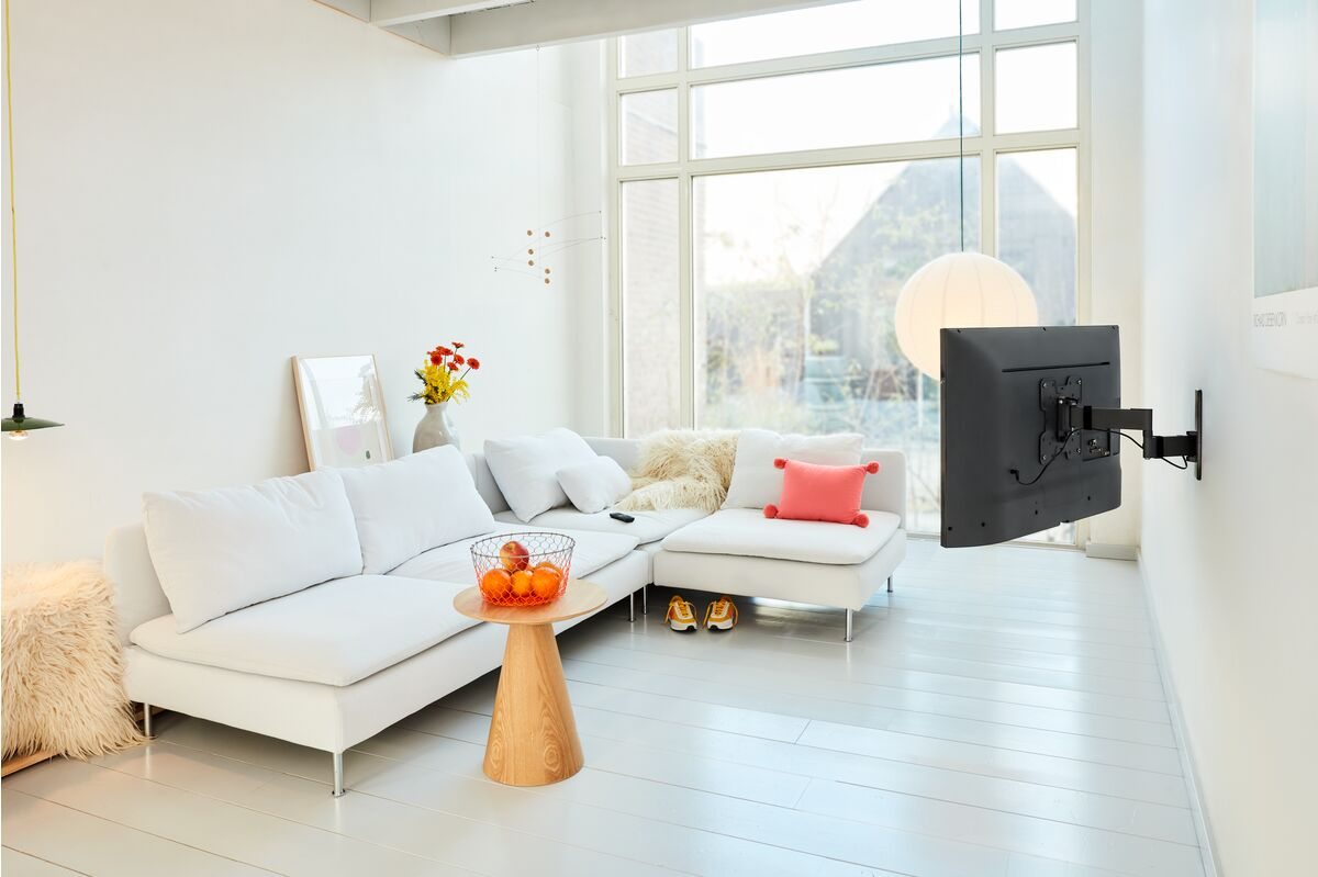 Salón con muebles blancos, TV en la pared, ventana. Luz brillante y natural.