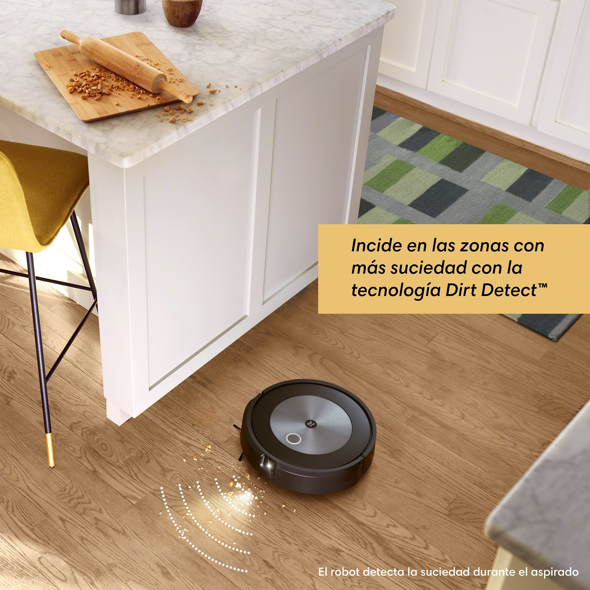 Aspiradora robot en piso de madera. Un mostrador de cocina en el fondo.
