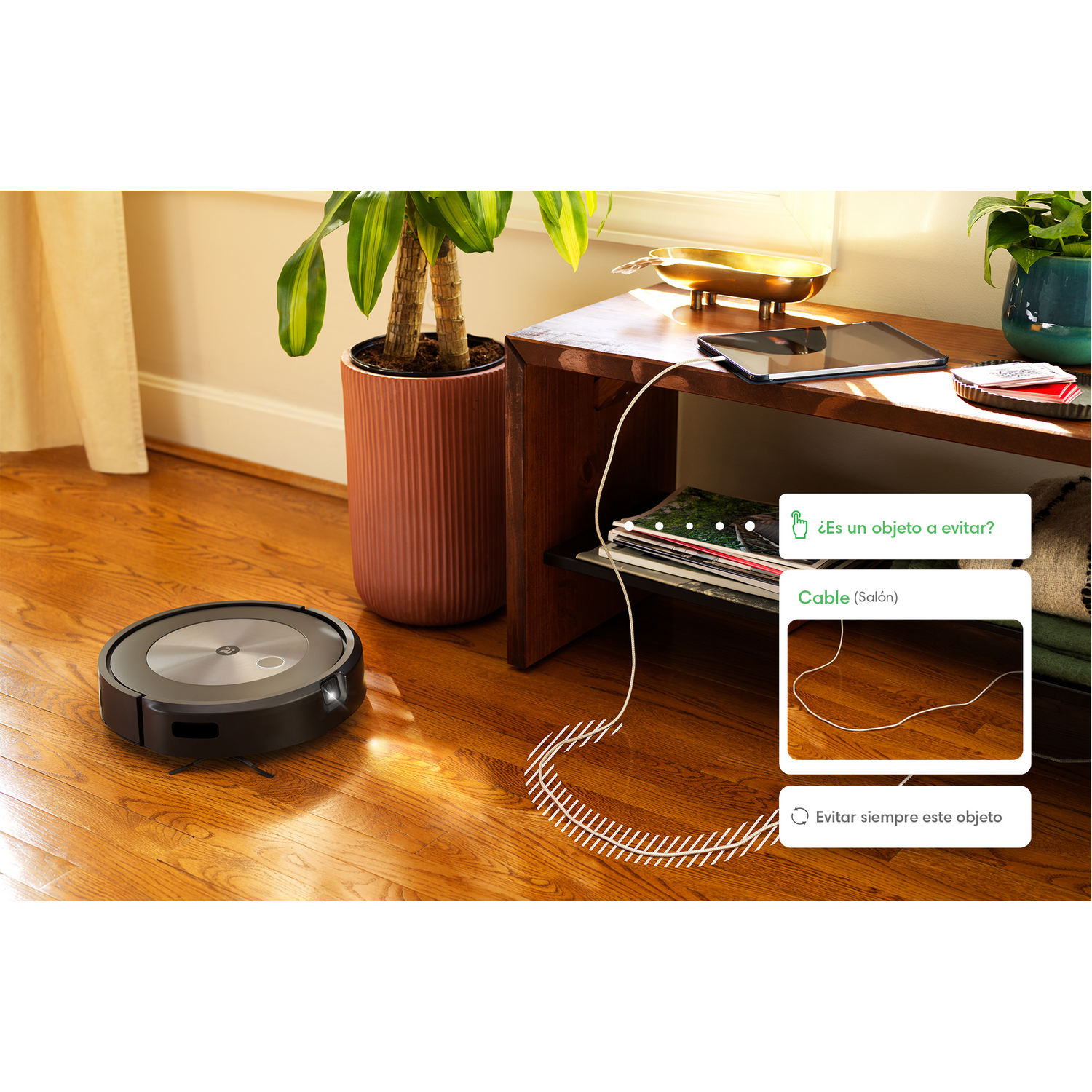 Aspiradora robot en piso de madera, cerca de una mesa con plantas y una revista. Superposiciones de texto.