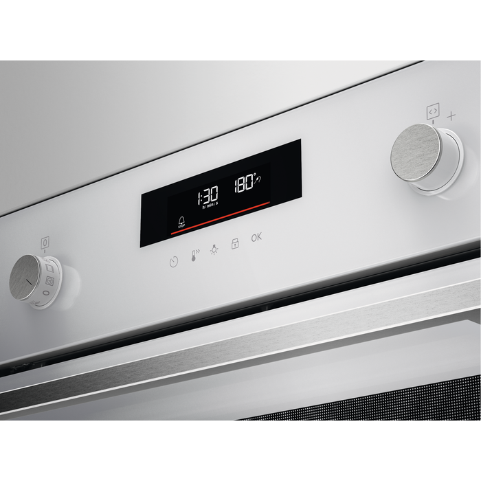 Panel de control del horno con pantalla digital que muestra la hora y la temperatura. Superficie blanca.
