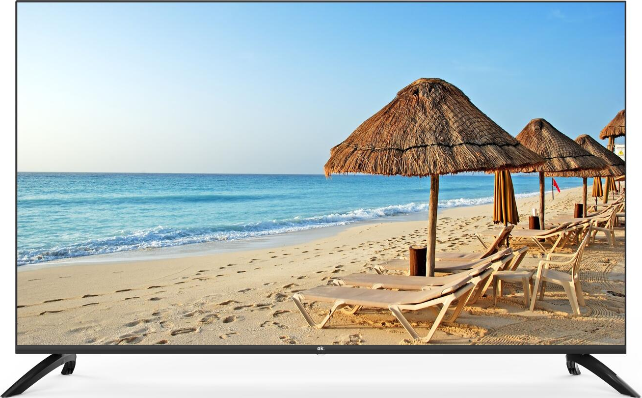 Un televisore su un supporto mostra una scena di spiaggia con ombrelloni e sedie.