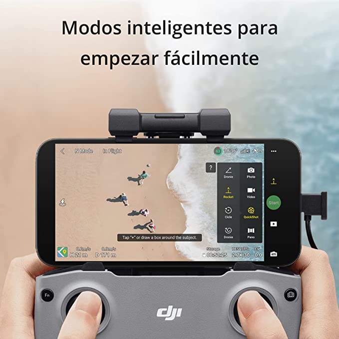 Manos sosteniendo un smartphone con control de dron, fondo de playa e interfaz de dron.