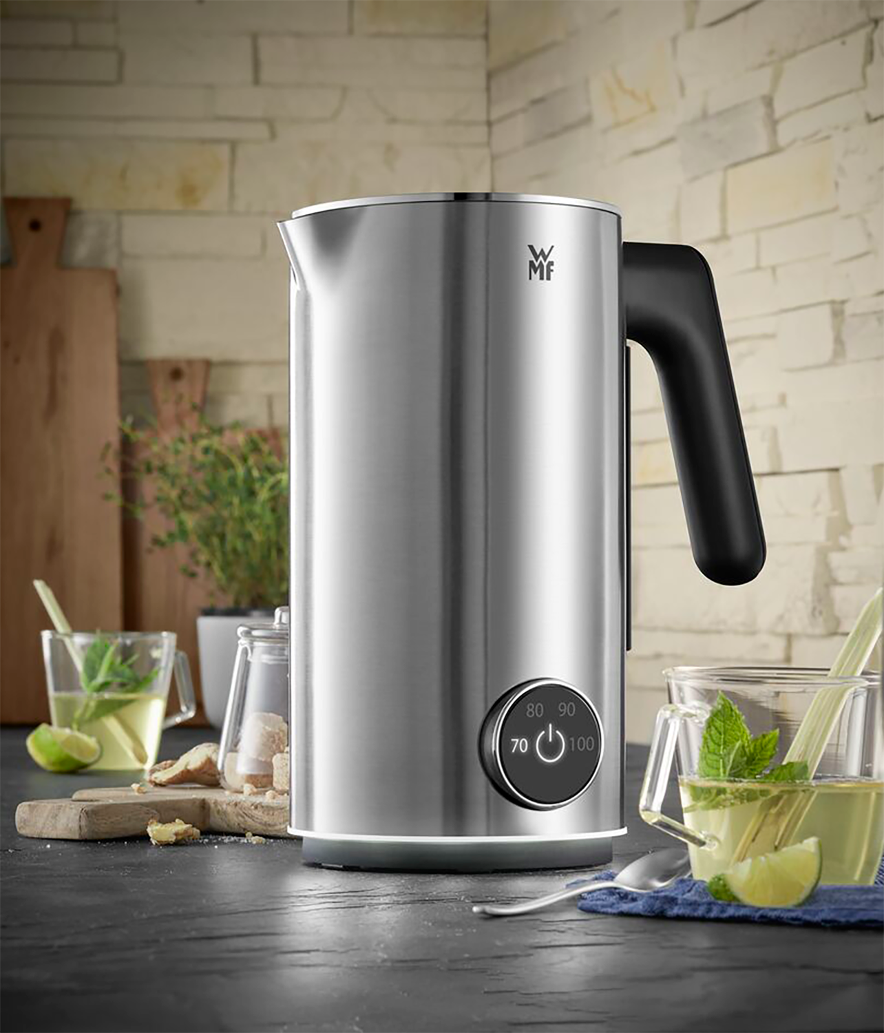 Silver electric kettle with a black handle. Tea and glass cups are present.