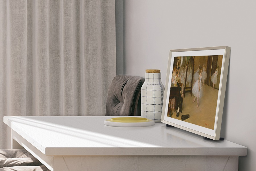 TV su un tavolo, che mostra un dipinto. Un vaso e una sedia sono sul tavolo.