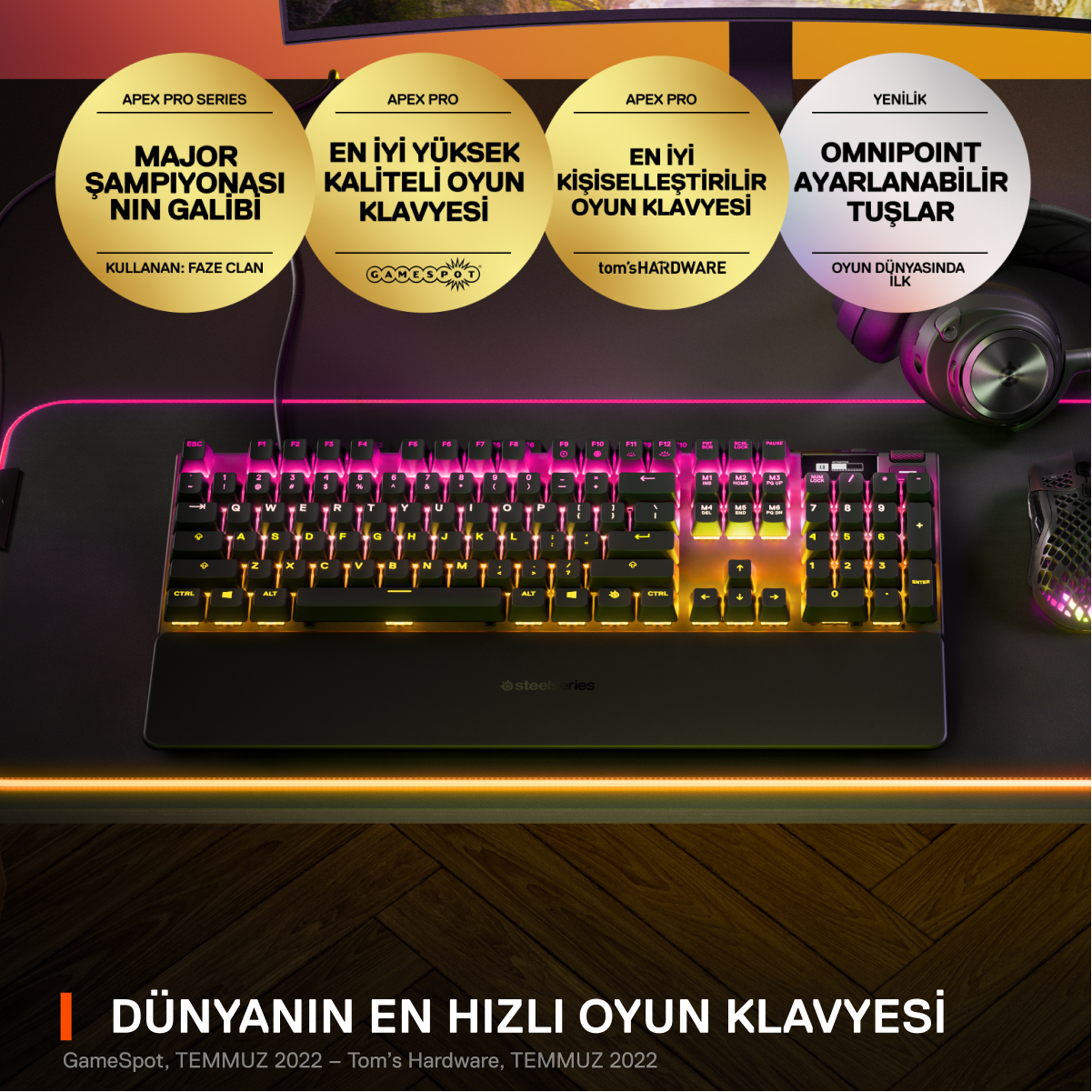 Bilek desteği, aydınlatmalı tuşlar ve altın vurgulara sahip siyah ve gri klavye. Yukarıda bilgilendirici grafikler.