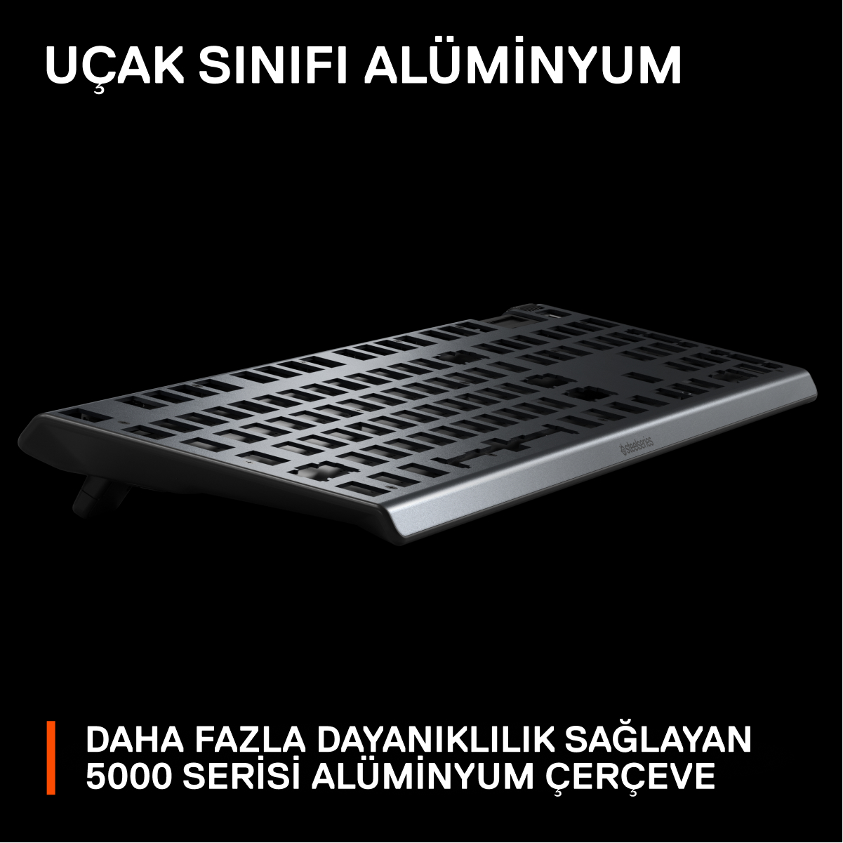 Siyah klavye, yukarıdan görünüm, 'Uçak Sınıfı Alüminyum' yazılı, alüminyum çerçeve.