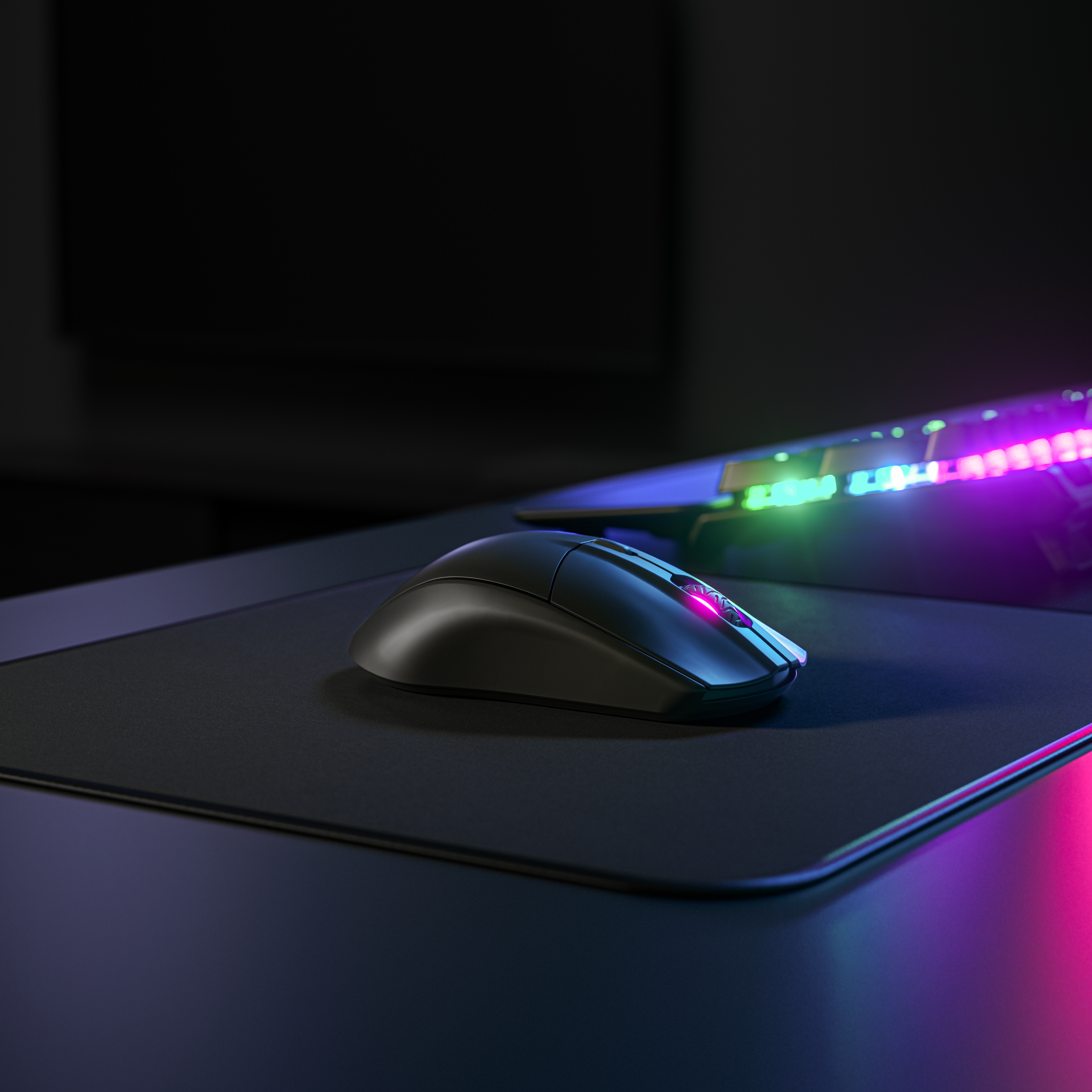 Siyah bir oyun faresi, siyah bir mousepad üzerinde. Farenin bir ışık şeridi var.