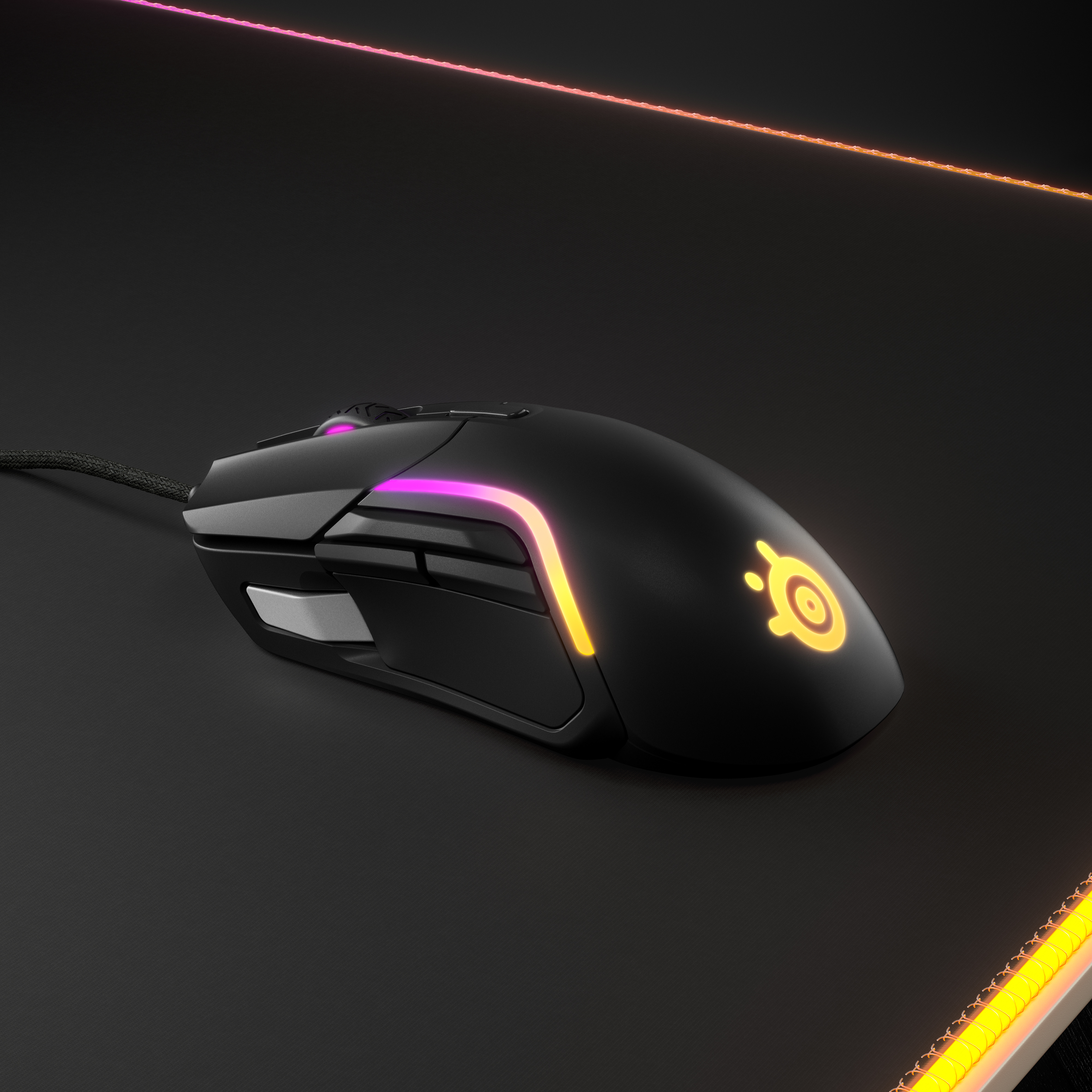 Siyah bir mouse pad üzerinde siyah bir fare, renkli bir ışıkla.