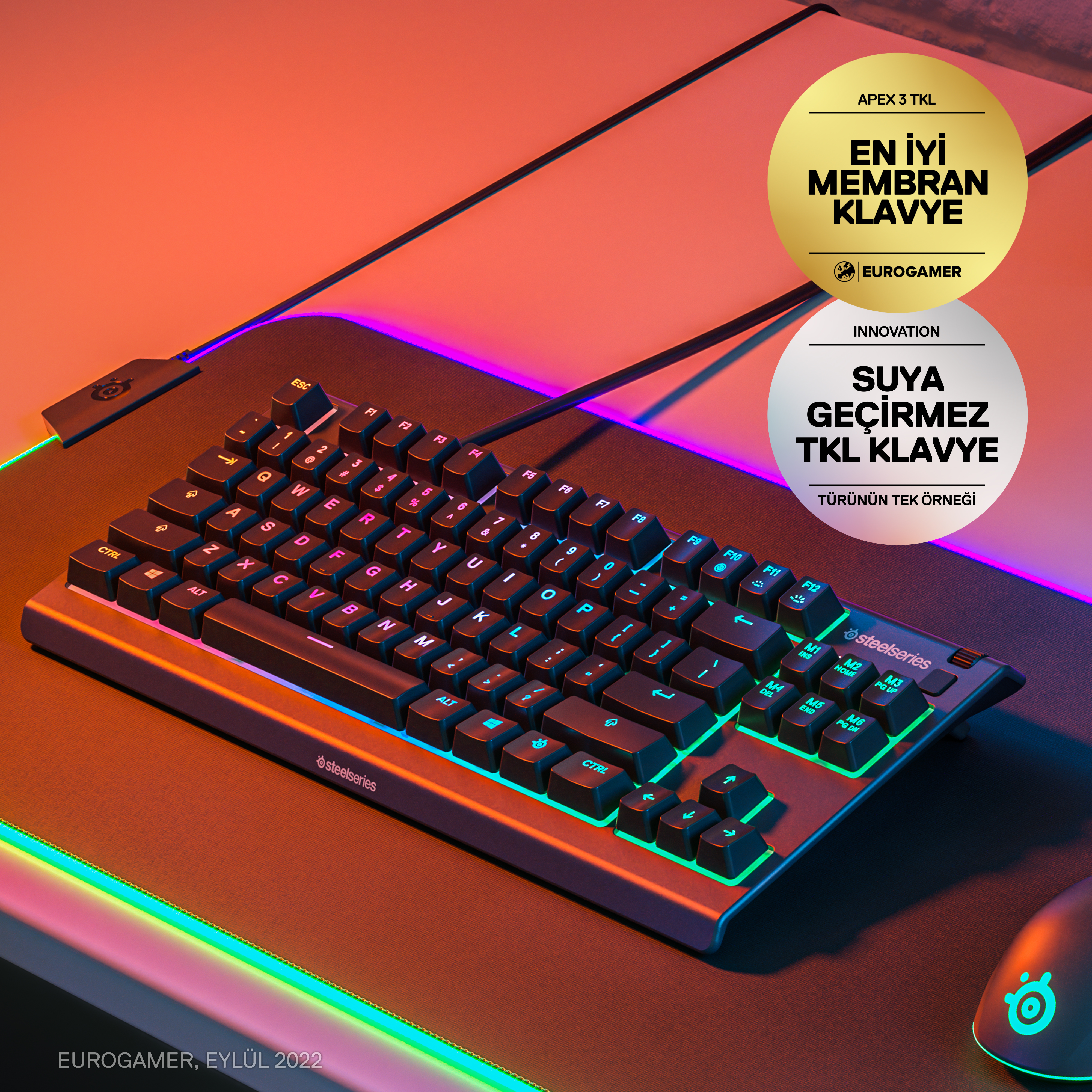 Yeşil arkadan aydınlatmalı tuşlara ve sağ üstte iki etikete sahip siyah bir klavye.