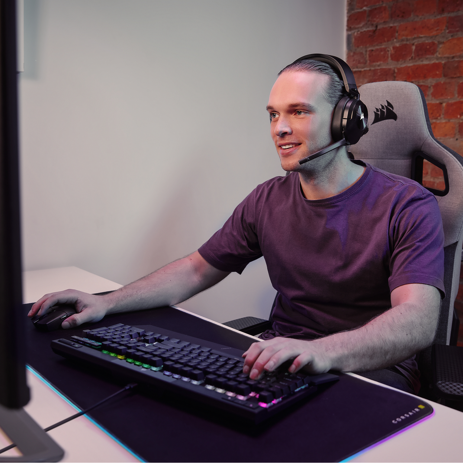 Man met een headset aan het gamen terwijl hij naar de monitor kijkt.