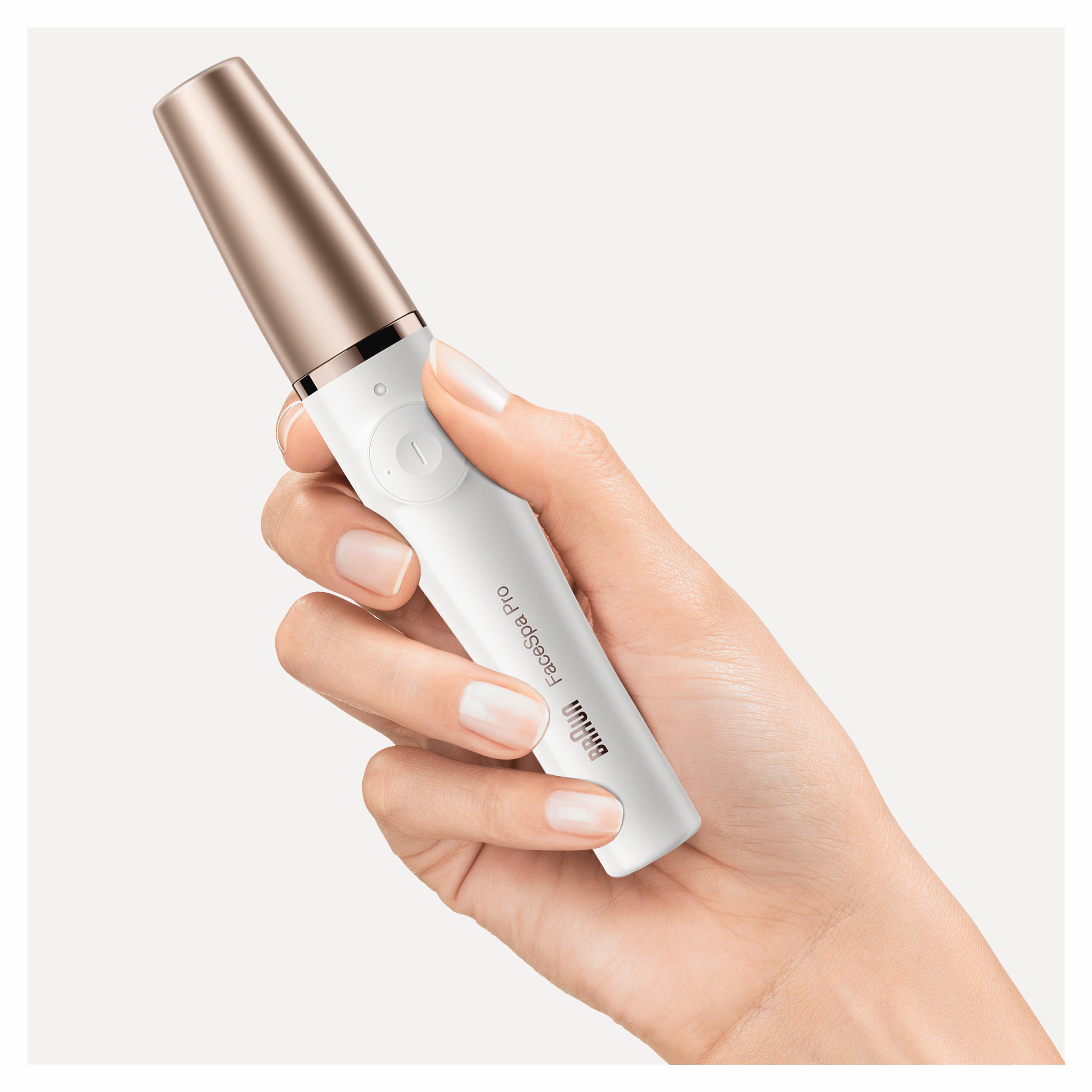 Eine Hand, die einen weißen und roségoldenen Braun FaceSpa Pro Epilierer hält.
