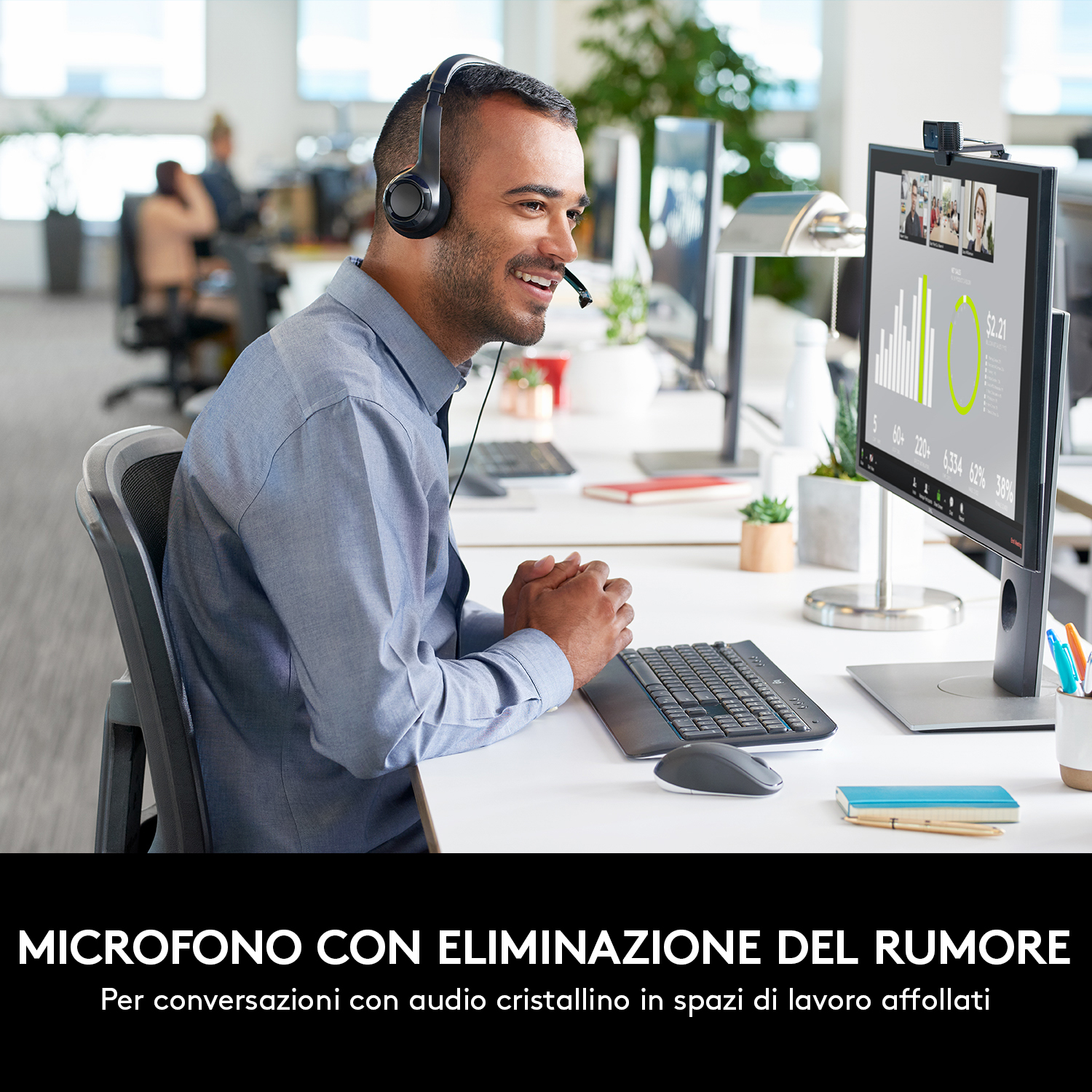Uomo con camicia abbottonata con auricolare a una scrivania con un computer.