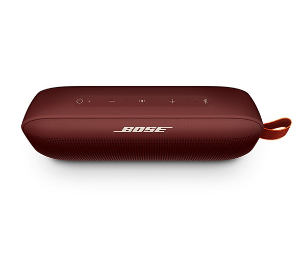 Altavoz Bose granate con botones superiores y correa sobre fondo blanco.