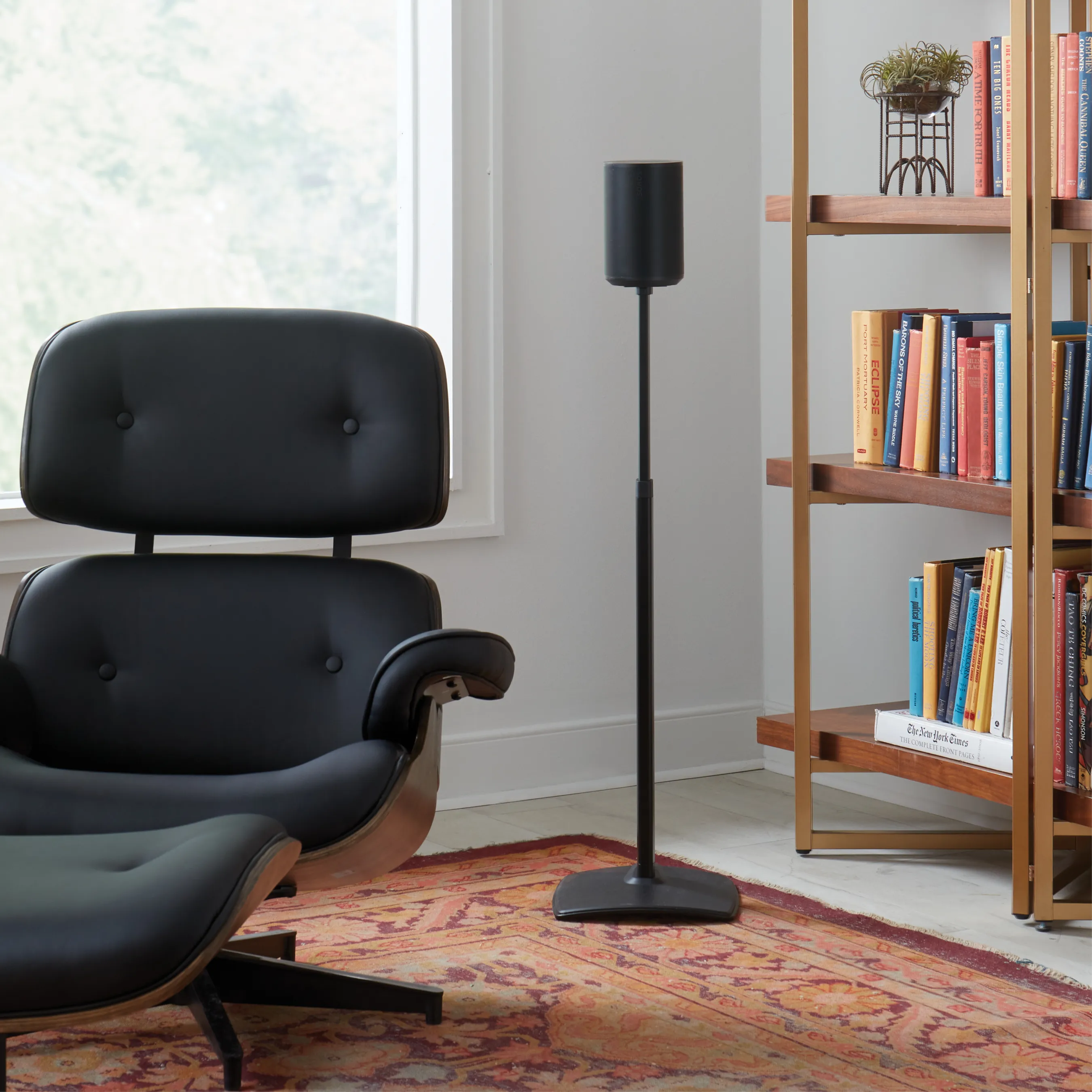 Wohnzimmer mit Lautsprecher auf Ständer. Schwarzer Stuhl, Bücher, Fenster.